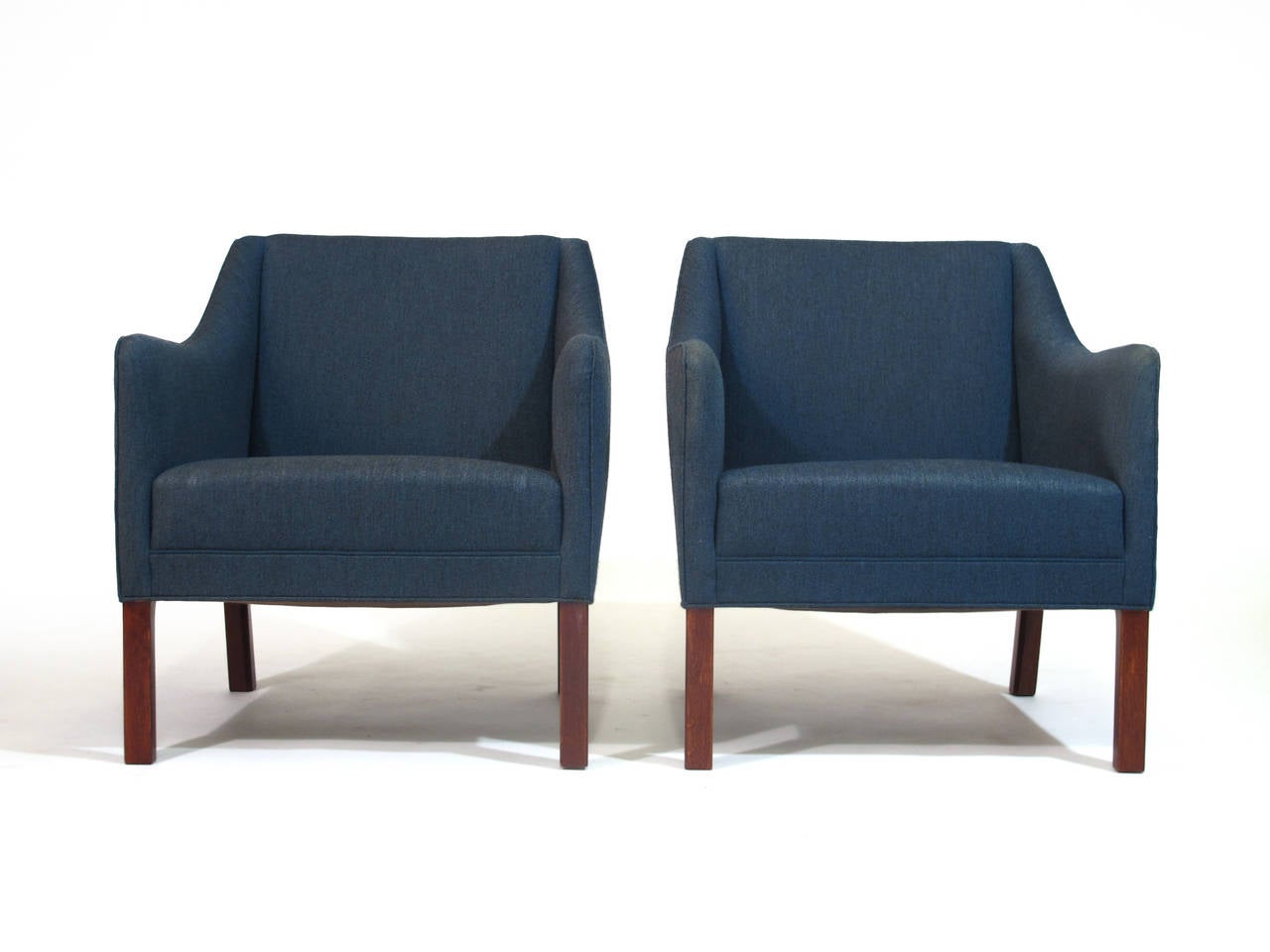 Scandinavian Mid-Century upholstered lounge chairs in original blue wool fabric. Designed by Børge Mogensen and Hans Wegner for Johannes Hansen. Solid wood frame with hand tied spring seat, raised on mahogany stained oak legs. Shown at the
