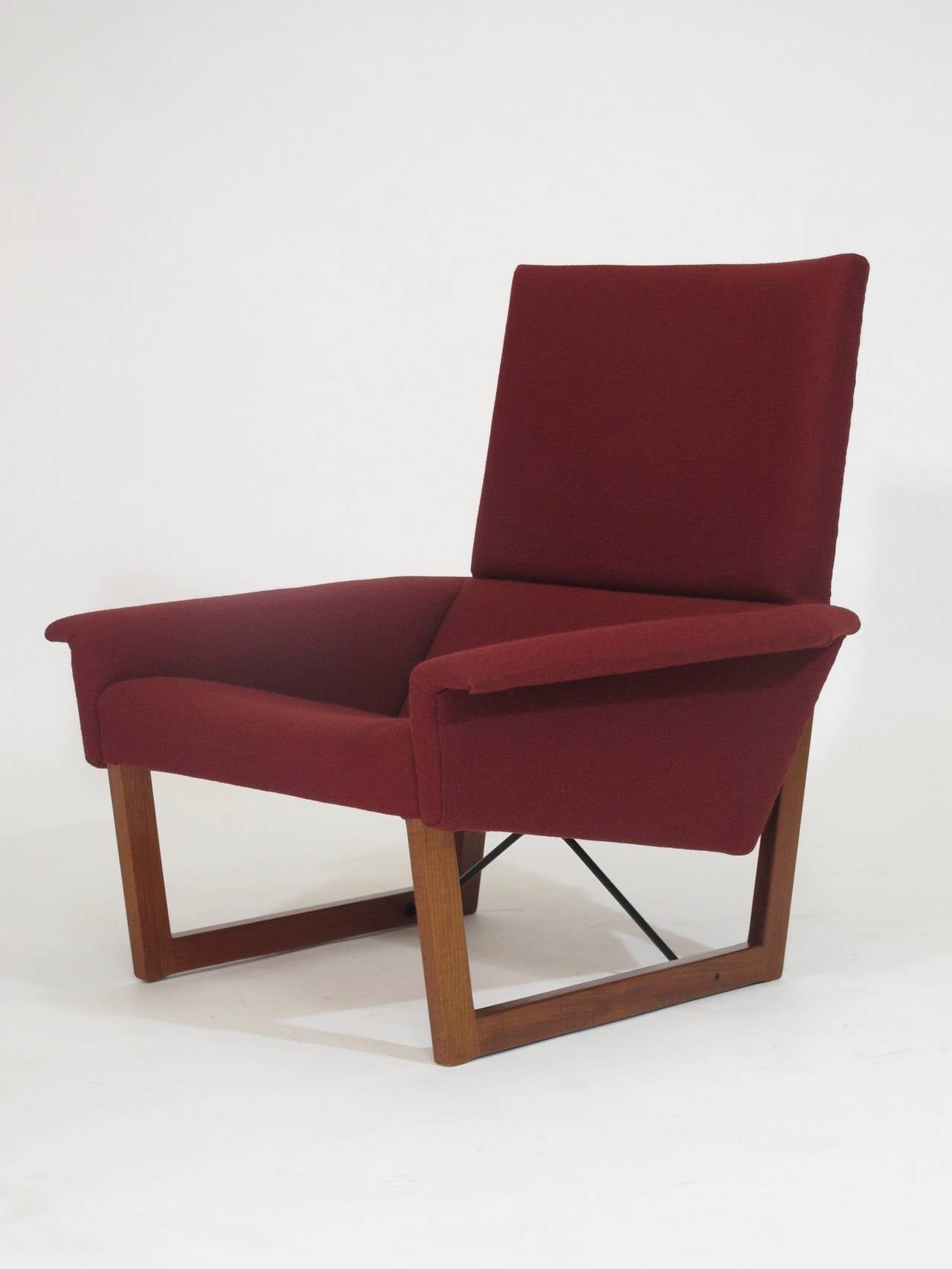 Mid century lounge chair upholstered in original red wool fabric raised on teak frame with angled metal cross stretcher designed by Illum Wikkelso for Hjorring Madrasfabrik model # 113
