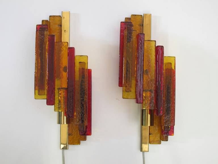 Wall sconces crafted of yellow, orange, and red pressed glass stacked in spiral form and mounted on a brass fixture by HT Rustik, model 15, for Hassel & Teudt.