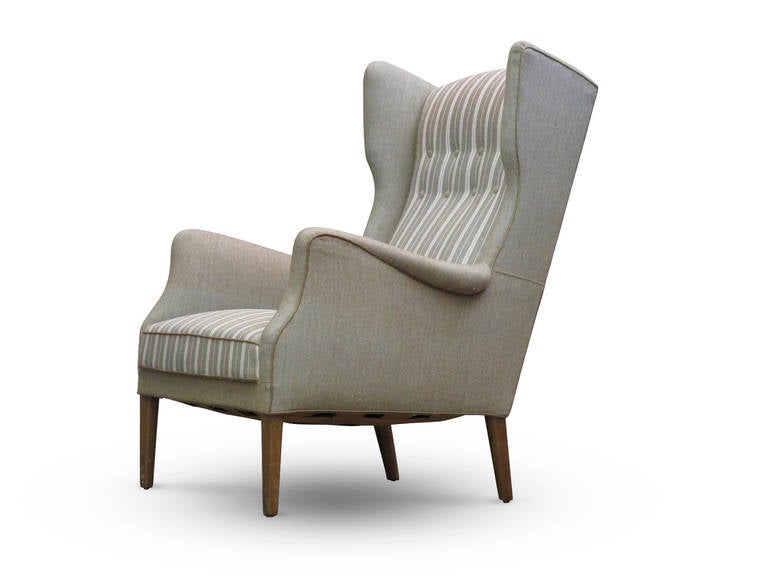 Midcentury Danish wingback chair designed by Tage Wernersen for Christensen, Denmark in 1947.
Solid wood frame with eight-way hand tied springs and horsehair padding covered in the original striped wool fabric with button tufted back.
Raised on