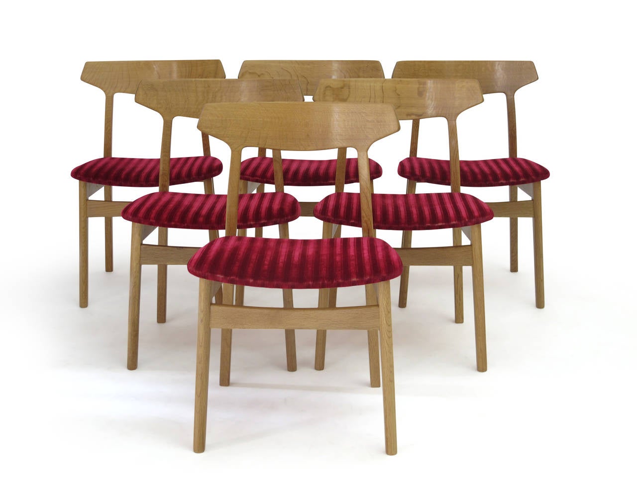 Six Mid-Century white oak dining chairs by Danish designer Henning Kjaernulf, model #60. Manufactured by Bruno Hansen and Christensen and Larsen. Solid quarter sawn oak frames with tiger graining, sculpted backrest with vintage red mohair textile on