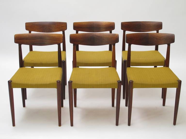 Six Mid-century Brazilian Rosewood dining chairs designed by Knud Faerch for Slagelse, Denmark, model #343. Exquisite solid Brazilian Rosewood with hand-carved curved backs, joined in center for book-matched effect. Original fabric seats.