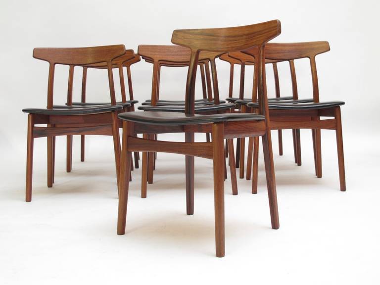 Ten mid-century Brazilian rosewood dining chairs by Danish designer Henning Kjaernulf.  Model #60. Manufactured by the cabinetmakers Bruno Hansen and Christensen & Larsen. Each stamped with cabinetmakers mark. Newly upholstered in soft, full aniline