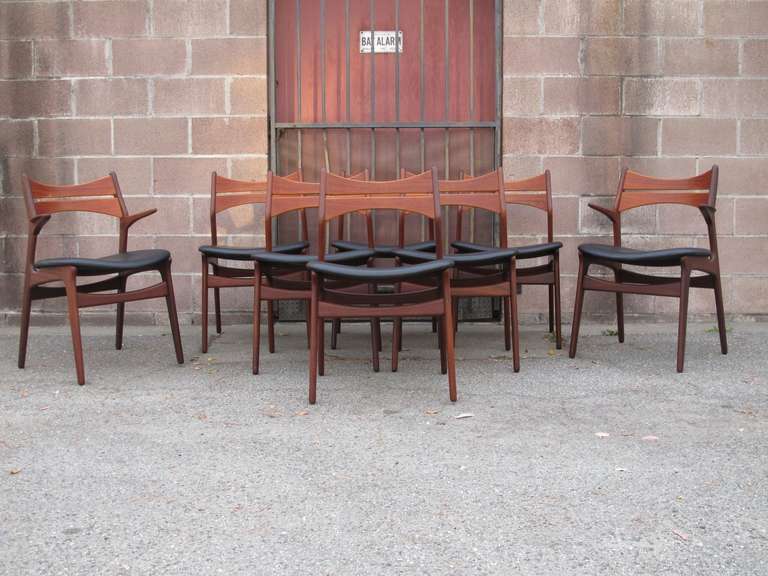 Set of eight Danish dining chairs designed by Erik Buck for Christiansen, Denmark. Walnut frames with comfortable teak back rest, newly upholstered seats in black vinyl. Includes six side chairs, and two arm chairs.

Set of twelve available upon