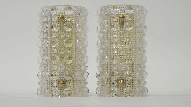 Pair of Orrefors crystal wall sconces with brass backplates designed by Carl Fagerlund, produced by Lyfa in collaboration with Orrefors, Sweden.