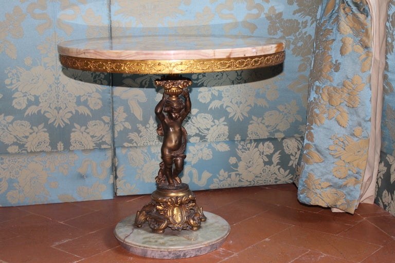 Italy, 20th century
A beautiful side table with a burnished and gilt bronze putti sculpture supporting a precious round onyx top. The table rests on onyx circular base. Intricate gilt details. Perfect conditions
Measures: Height 59 cm, Diameter 62
