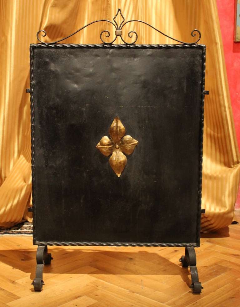 Hand wrought iron black lacquered and parcel gilt fire screen panel, manufactured in Florence in late 19th Century standing on curled iron feet

Measures: Width 51 cm, height 80 cm, depth max 24 cm.
 