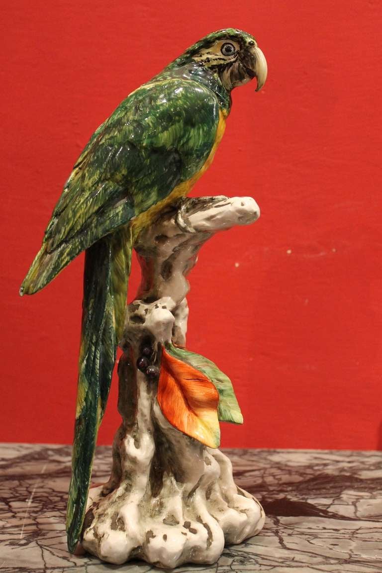 Italy, 1930 circa
This Brightly Colored Porcelain Parrots figure is perching on floral encrusted tree stumps. It bears the mark on the base 