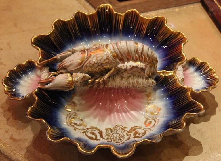 A rare French Sevres style manufacture scallop shell form centerpiece or Hors-D'oeuvre plate depicting a lobster holding a small fish. A fancy and unusual item to add in your table decor.
Wonderful blue royal, pink and gold coloration. Sevres