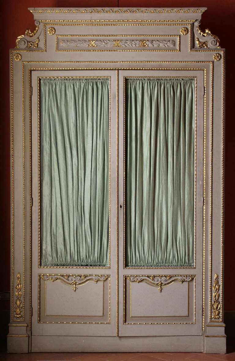 An imposing pair of 19th century lacquer display cabinets or bookcases of shallow depth with finely carved gilt details. These stunning cabinets feature the original glass doors that reveal an extensive amount of interior shelving all of which is