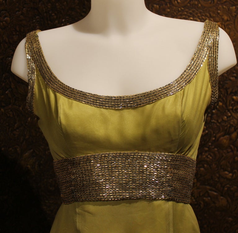 I proudly offer for sale this absolutely stunning evening gown with classic empire shape and a fantastic blend of green silk chiffon dress by Pierre Balmain. It is exquisitely decorated with precious glass Murano beads in gold and brilliant grey