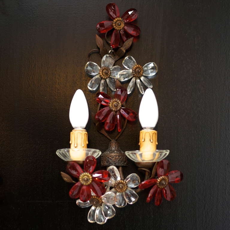 A stunning pair of sconces from the fifties in the manner of Maison Baguès. These have been made in Italy and were constructed using crimson and clear colored crystal for the flower heads and brass for the main body of the sconces. Really stunning,