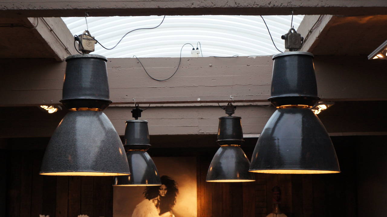 Four Industrial down-lighters from the 1940s. Completely enameled inside and out. Greyish black on the outside, white on the inside. Great looking in a bar, a loft or over your kitchen table!