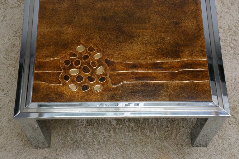 Mid-Century chrome coffee table with one complete hand-painted top in abstract motif with gold brown background.