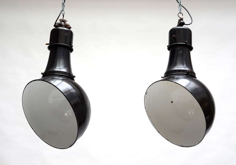 Enamel workbench light. Angular light fixture that was placed on the walls of factories and workshops to light up a workbench. Thick black enamel on the outside, white enamel on the inside. Rewired for safety but otherwise completely original. A