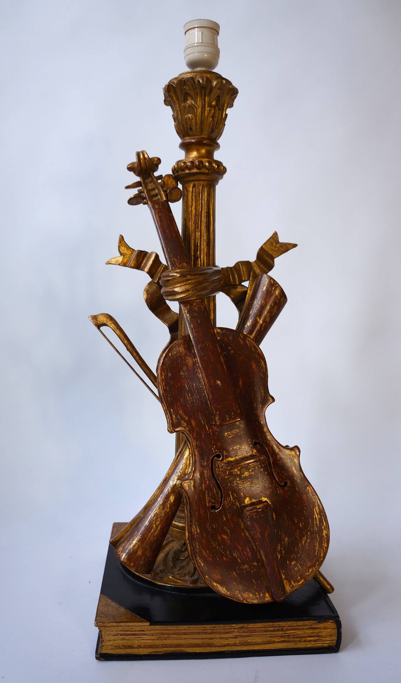 Antique carved violin table lamp.
A very charming antique table lamp with carved bases and column center, adorned with carved wooden violin, bow and scrolled music. Painted, brown and gold. Very good condition.