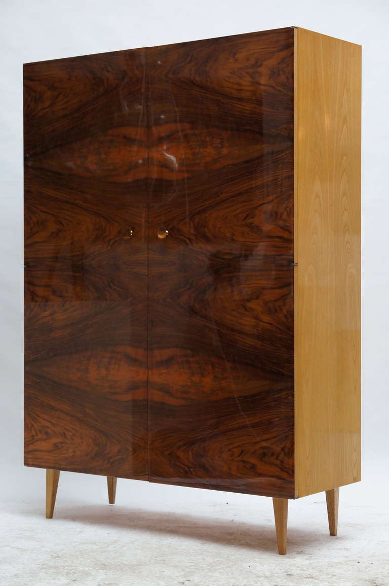 Wood walnut highboard with wooden doors and tapered legs. It is a spectacular design from the 1950s that makes this piece an icon of contemporary design.