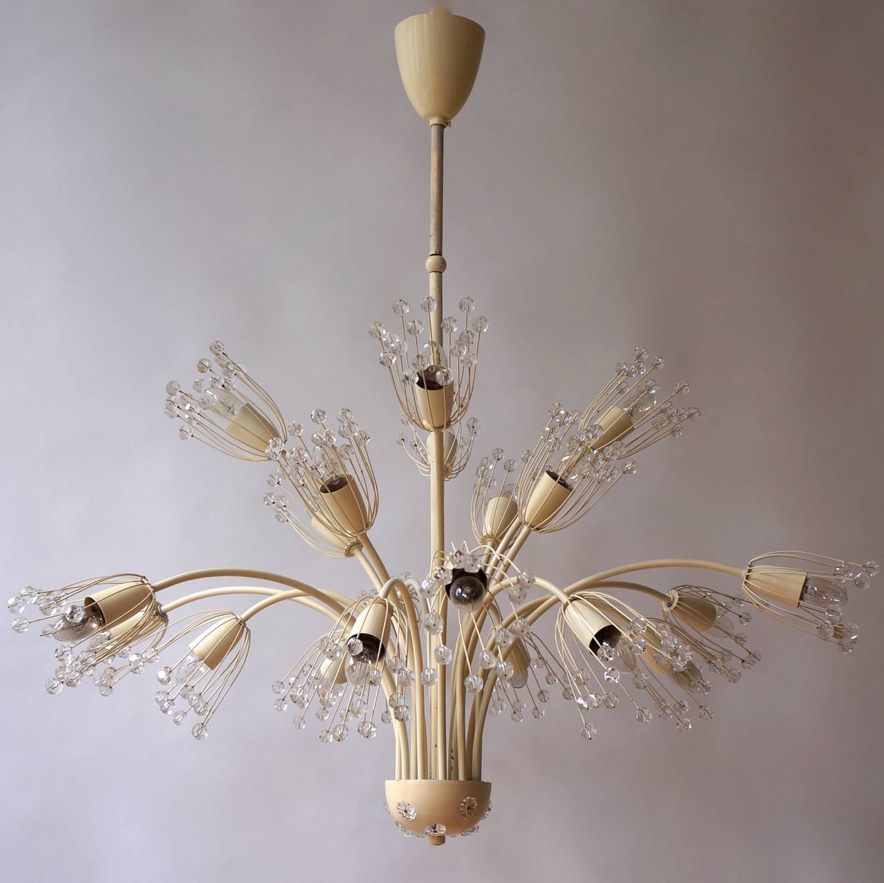 A beautiful chandelier made by Emil Stejnar for Rupert Nikoll, Austria in the 1960s. The lighting has an amazing midcentury design.It is made of brass and small glasses.The fixture has a very nice Hollywood Regency floral design.

Total height: 110