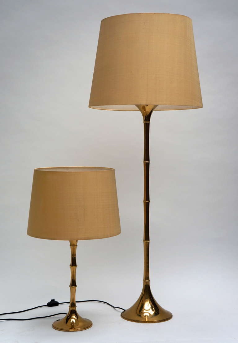 Set of an Ingo Maurer floor and table Lamp, both with original shade. 
Rare pair of brass faux bamboo floor and table lamps designed by Ingo Maurer for the company he founded called Design M in Munich Germany. We will separate the pair upon