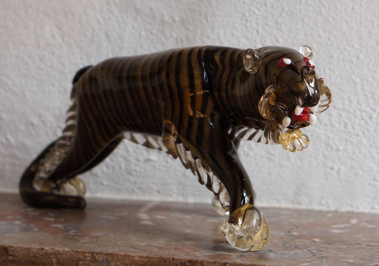 Tiger.
Alfredo Barbini, 1950.

Incredible large 15" long Murano handblown black and gold flecks art glass tiger sculpture. The piece is well detailed, with ears back, roaring with a force that shows through all its muscles, taking menacing