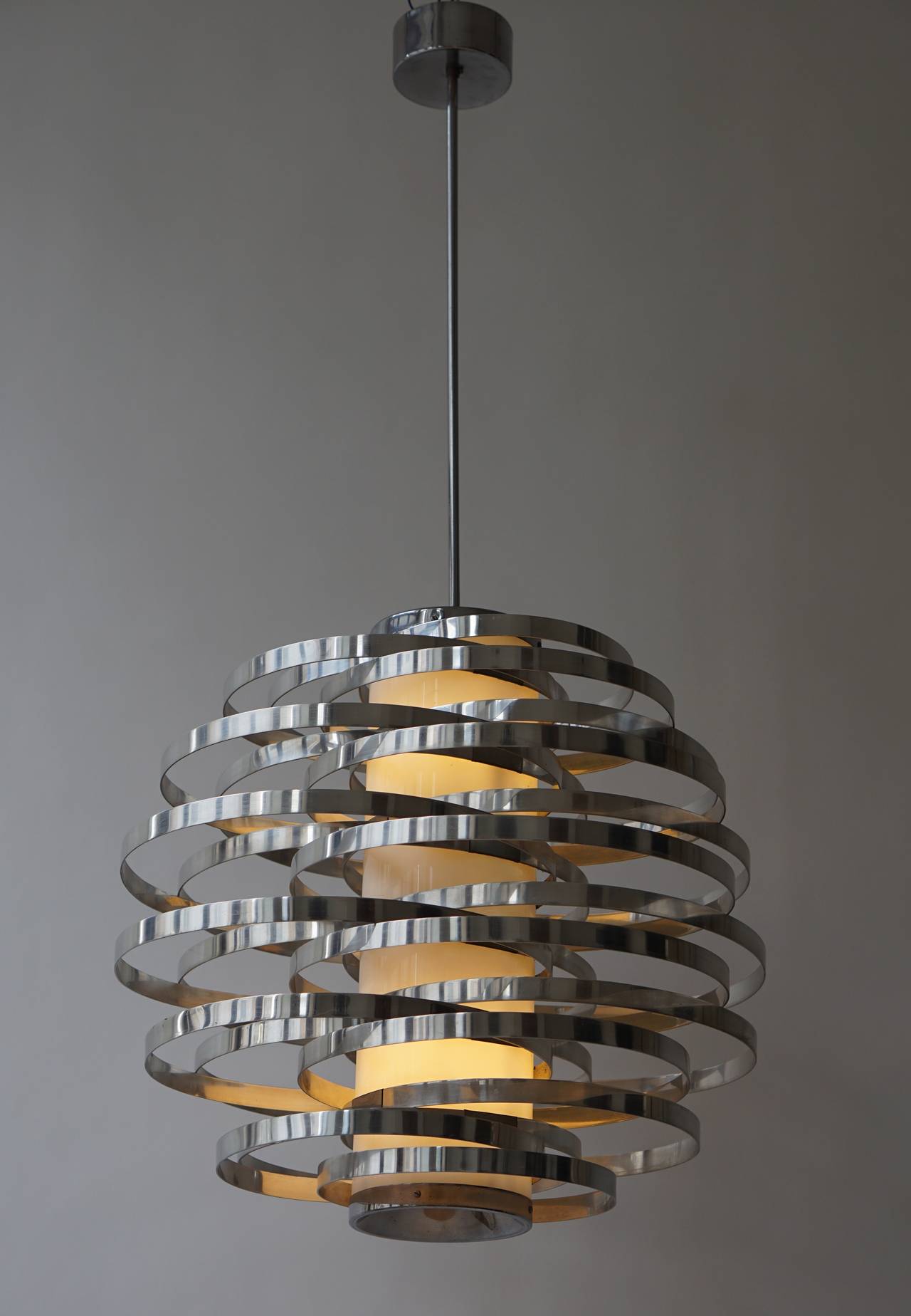 Chandelier of aluminium bands encircling an acrylic tube, with single bulb, on chrome stem. Sciolari, Italy, 1960s.
This is the large model.