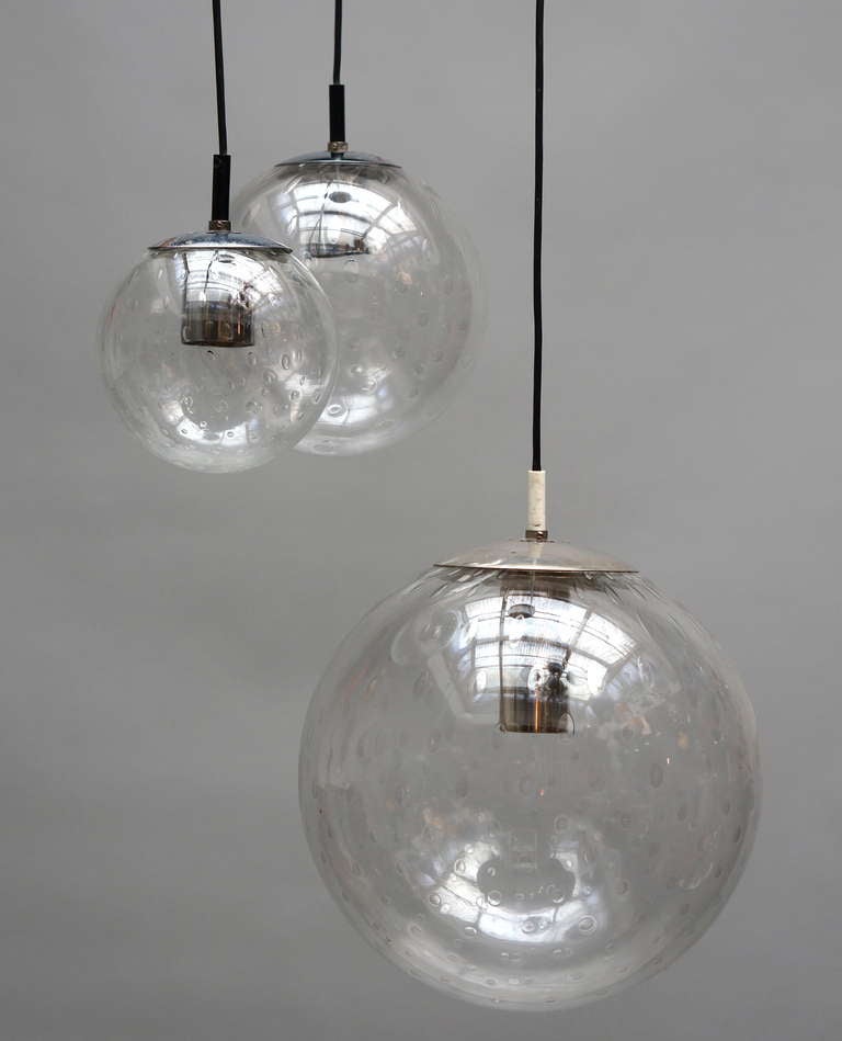 Three 'bubble' glass globes suspended at variant and adjustable lengths.