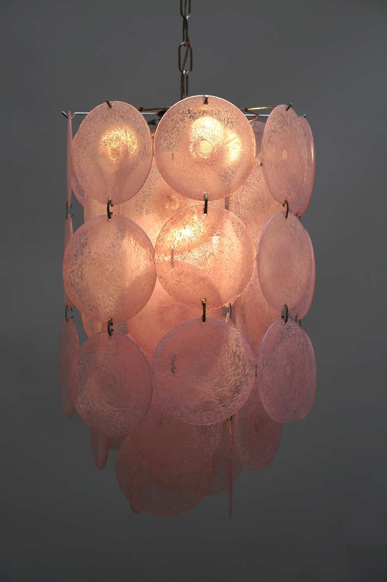 Venini chandelier with 54 discs.

 The chandelier has four sockets for small incandescent lamps with screw base or E14 type LEDs and one E27 . It is possible to install this fixture in all countries (US, UK, Europe, Asia, Canada), although it may be