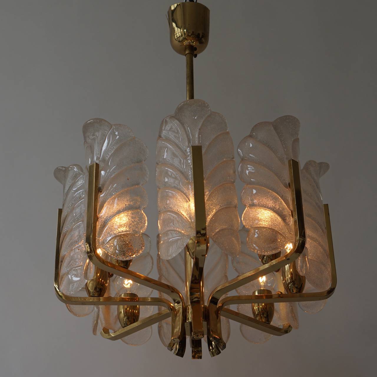 Un lampadario in ottone con otto foglie di vetro.
Altezza totale 67 cm.
Diametro: 46 cm.
Altezza del dispositivo: 30 cm.