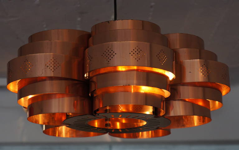 Copper pendant by Verner Schou for Coronell Elektro Denmark. 
In the style of Hans Age Jakobsson. Perforated red copper lamellae.
Measurements; 
Height: 7.1 in. (18 cm), 
Diameter: 14.6 in. (37 cm).
