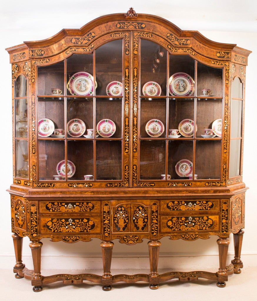 This is a stunning antique Dutch marquetry display cabinet circa 1780 in date. 

It has been accomplished in burr walnut with exquisite hand-cut marquetry of flowers, birds and urns, made from various exotic veneers and ivory, set into ebonised