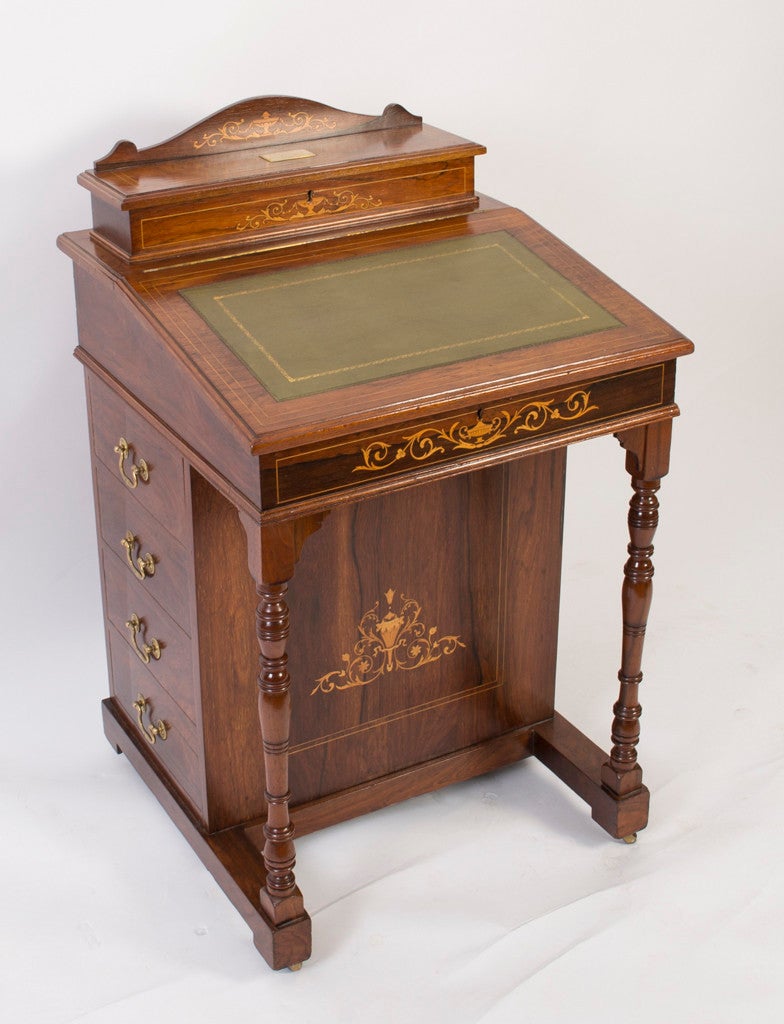 This is a beautiful Edwardian rosewood and marquetry Davenport circa 1900 in date. 

The desk features marquetry decoration, hinged stationery compartment, tooled leather inset to the slope front, fitted with four end drawers, matched by dummy