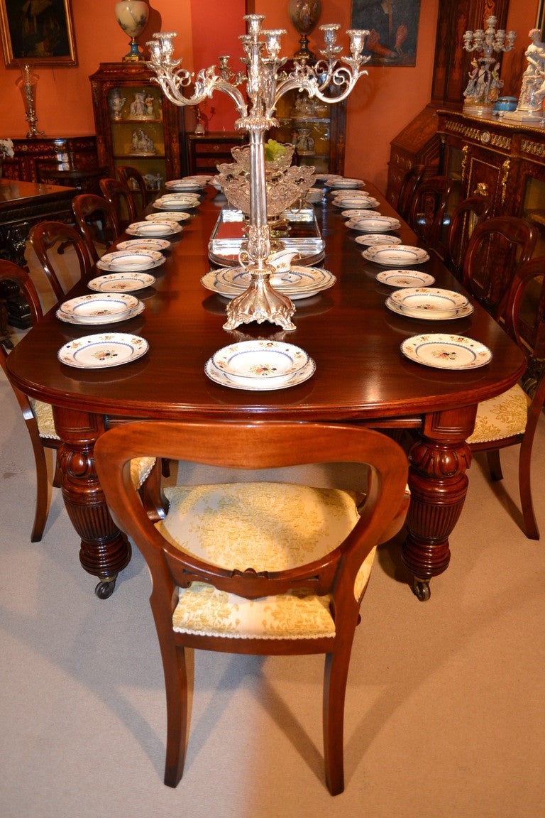 An absolutely fantastic antique English Victorian extending dining room table, Circa 1880 in date, with a set of twelve matching chairs, comprising ten chairs and a pair of armchairs.

The table has been masterfully crafted in beautiful solid