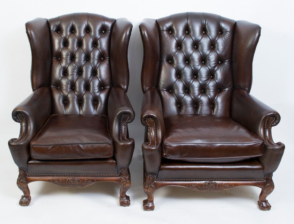 This is an absolutely fabulous pair of antique English handmade leather wingback Chippendale armchairs, circa 1900 in date. 

Standing on hand carved solid mahogany Chippendale style ball and claw legs with beautiful hand carved decoration around
