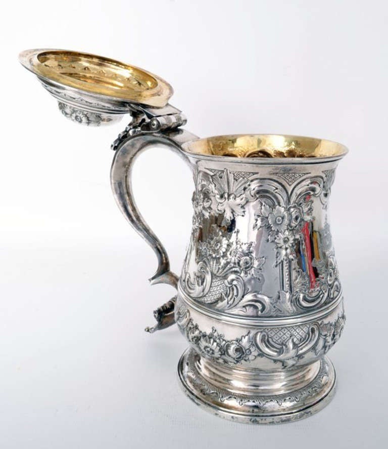 This is an exquisite antique George III English silver presentation tankard.
This tankard features London hallmarks from 1767 and the makers mark of William & James Priest.

The tankard has a domed cover with an ornate handle.

A truly