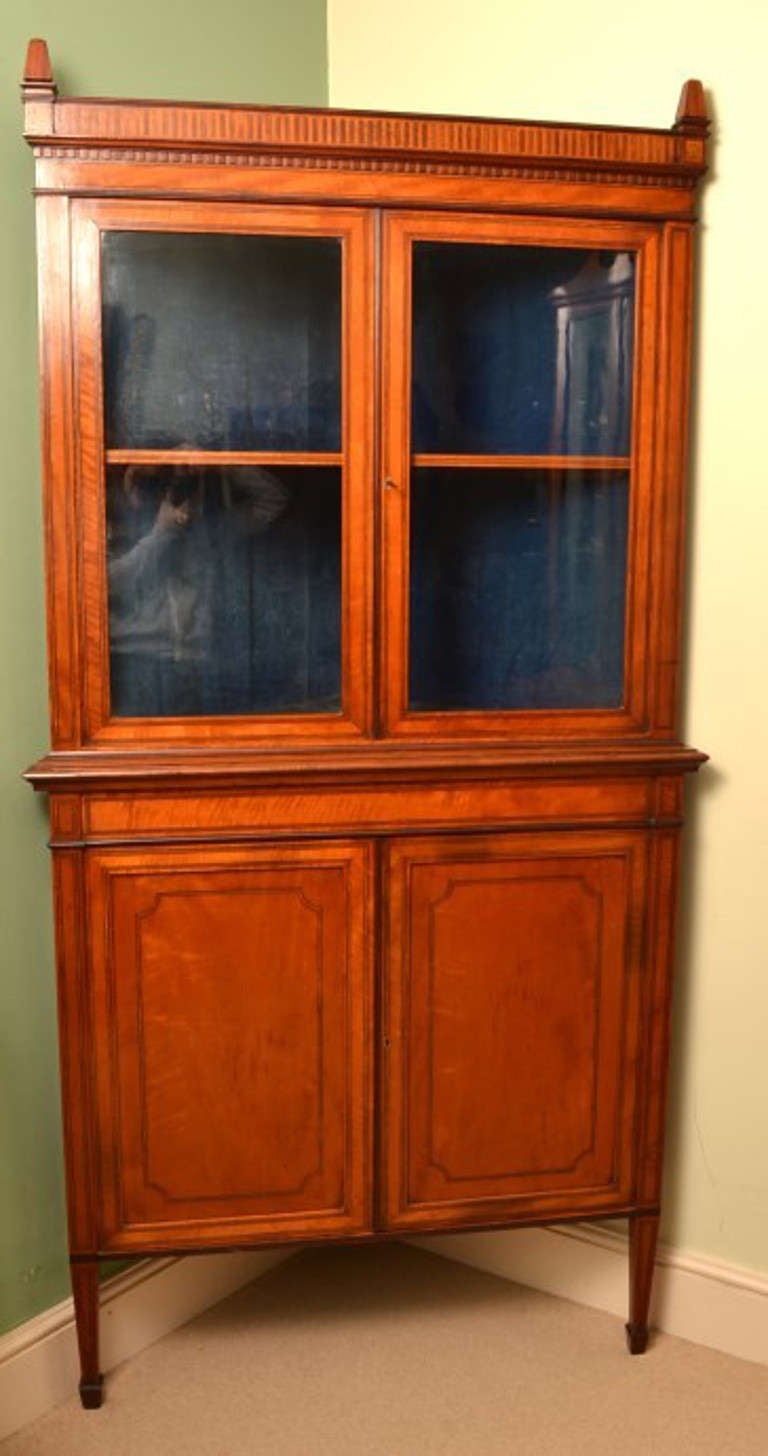 This is a fabulous antique English Edwardian satinwood corner cabinet, probably by Edwards and Roberts of Wardour Street London as it is very typical of their work.

It dates from about 1890, the end of the Victorian period and the start of the