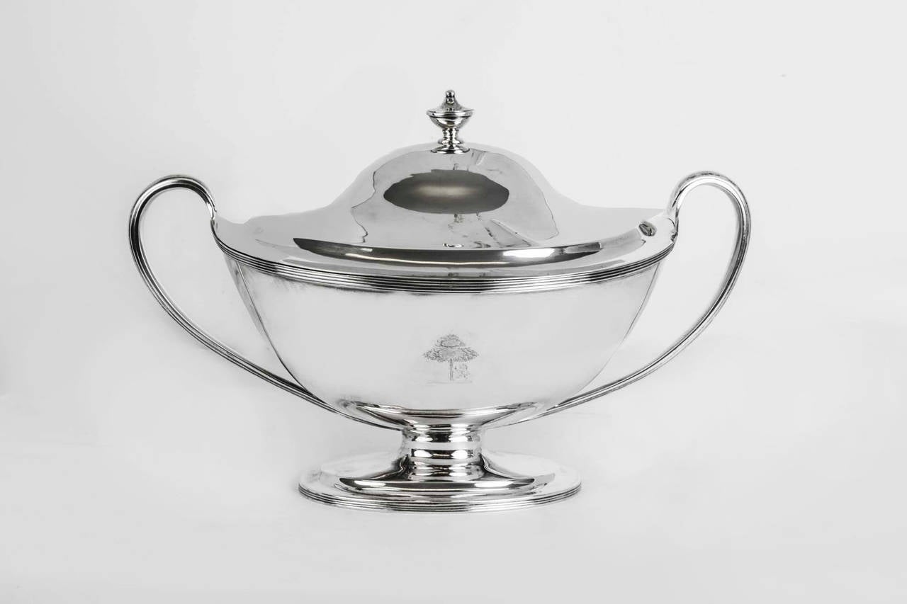 This is a wonderful antique English George III sterling silver tureen and lid, with hallmarks for London 1808 and the makers mark WB for William Bennett. 

The tureen is beautiful in its simplicity. 

There is an engraved crest and a fabulous