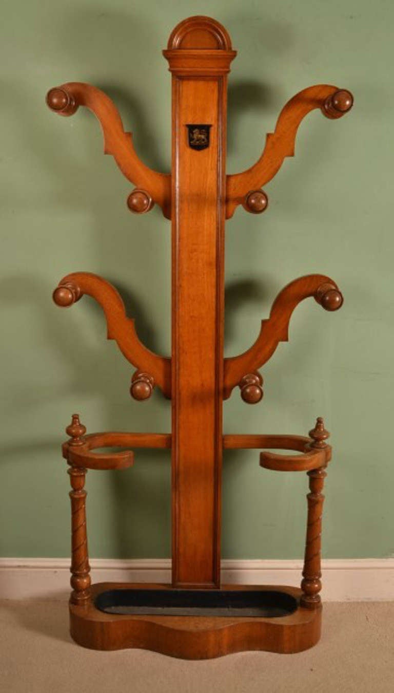 This is a stylish Victorian solid oak hall stand, circa 1860 in date.

The central pilaster is mounted with a painted shield and decorated with a lion crest. There is ample space to accommodate your coats, umbrellas and walking sticks, and the