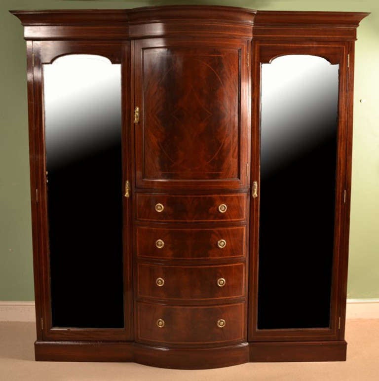 This is a lovely antique English inlaid flame mahogany wardrobe, circa 1880 in date.

It has been accomplished in the most beautiful 'flame mahogany' with fabulous crossbanded and inlaid decoration.

The wardrobe has a pair of mirrored