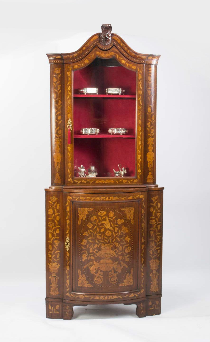This is an antique Dutch mahogany marquetry bow fronted corner cabinet which is circa 1780 in date. 

The cabinet has fabulous inlaid marquetry of flowering leafy stems, figures, and a fluted urn all outlined with barber pole and boxwood