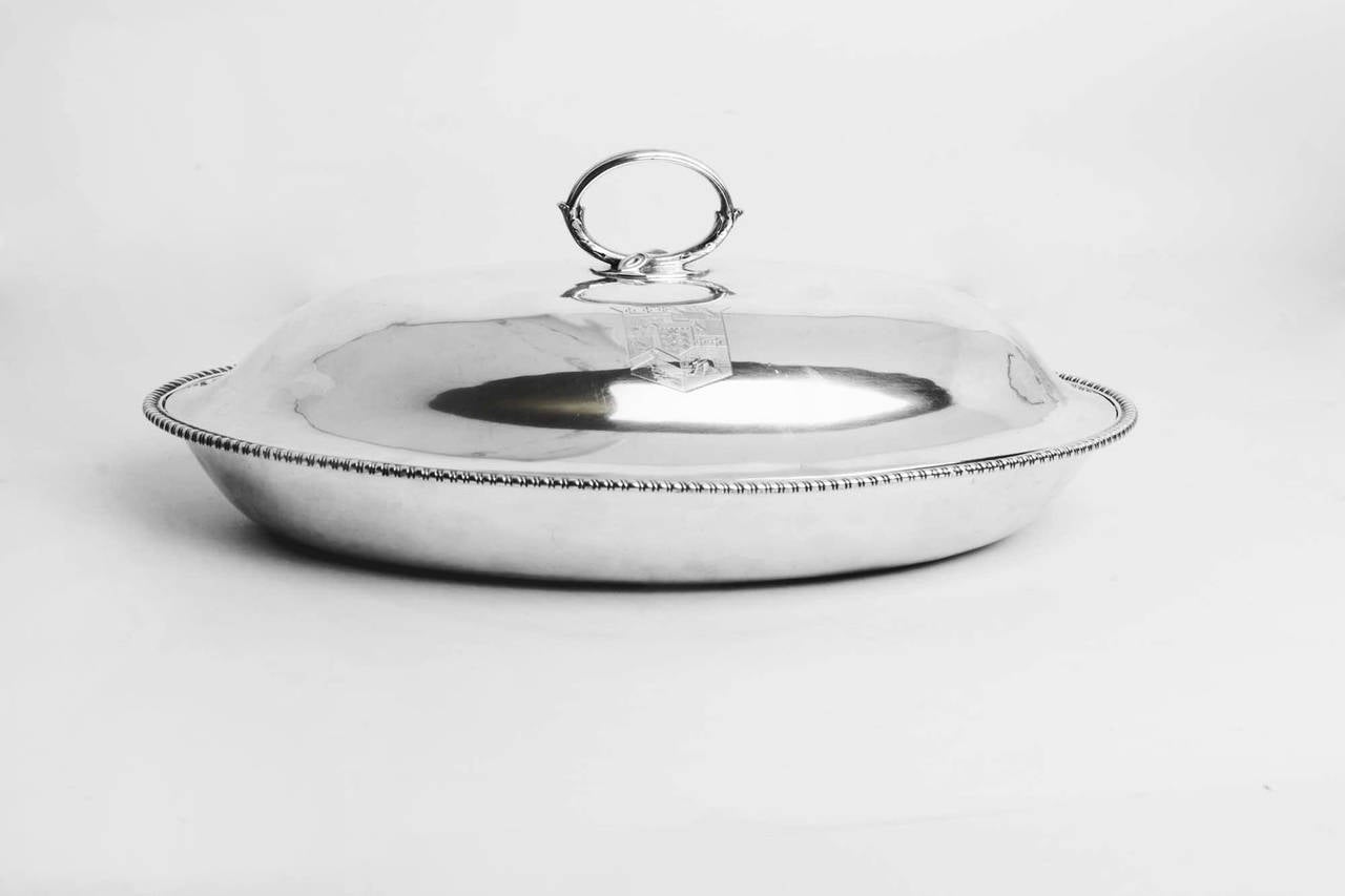 This is an elegant English antique sterling silver entree dish with cover by the world famous silversmith Paul Storr. 

It has hallmarks for London 1796, the makers mark of Paul Storr and bears an interesting coat of arms : 

The Marital Arms of
