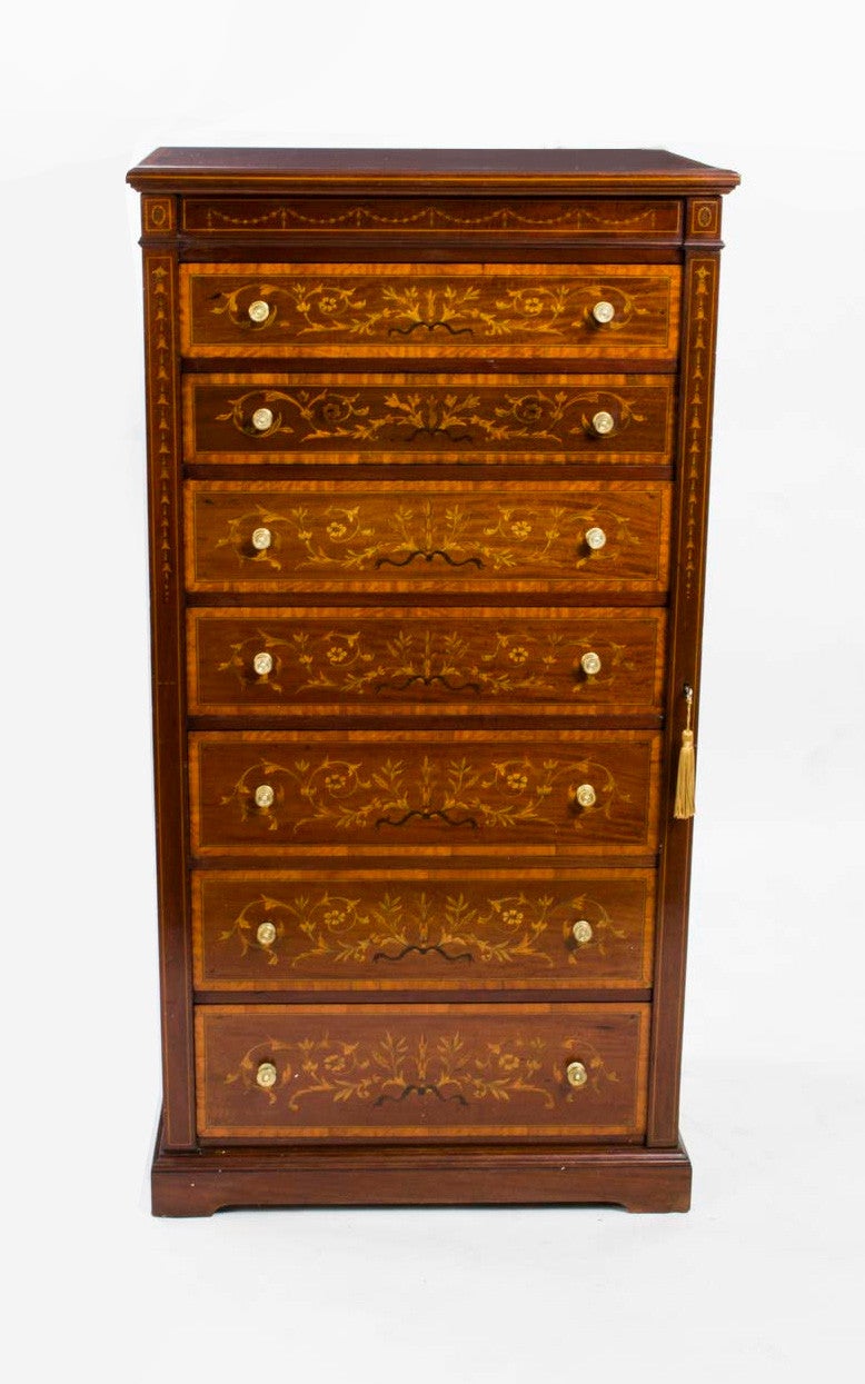 This is a stunning antique late Victorian mahogany and satinwood Wellington chest, circa 1890 in date.

The chest was made by the famous cabinet maker Jas Shoolbred & Co and the top drawer is stamped with his name. The chest stands on a plinth base