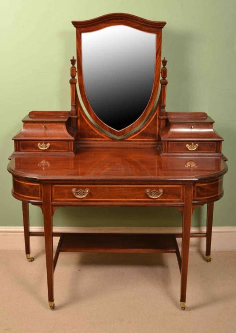 This is a totally fabulous antique inlaid mahogany dressing table with adjustable mirror by the World renowned cabinet makers Gillows of Lancaster, circa 1890 in date.

The `D` shaped top surmounted by a bevel edged shield shaped mirror with
