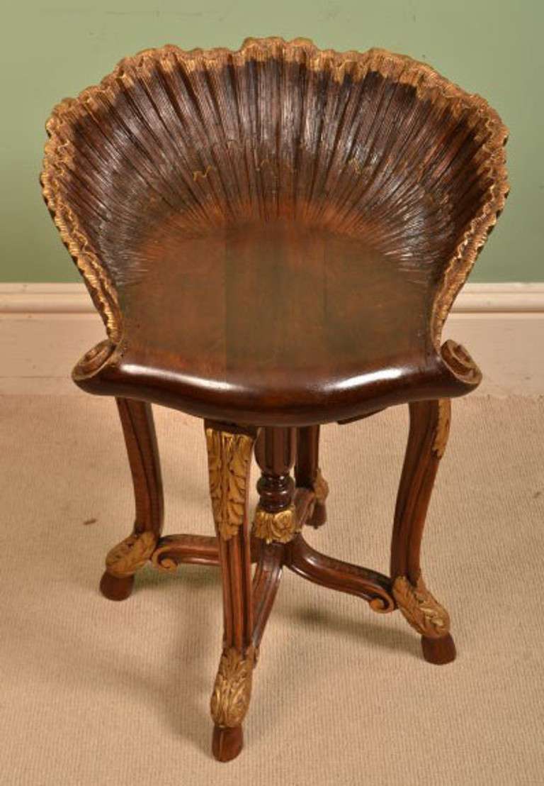 This is a beautiful antique North Italian walnut and parcel gilt Venetian grotto music stool, with an ornate shell carved seat, circa 1880 in date.

The revolving adjustable seat is raised on a circular base and decorated with gilt paterae and