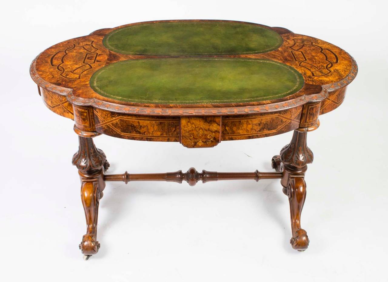 This is a fabulous antique writing table, circa 1880 in date. 

The desk is crafted from beautiful burr walnut and features two striking green leather writing surfaces. 

It is inlaid with interlaced strap-work bands on each end and it has