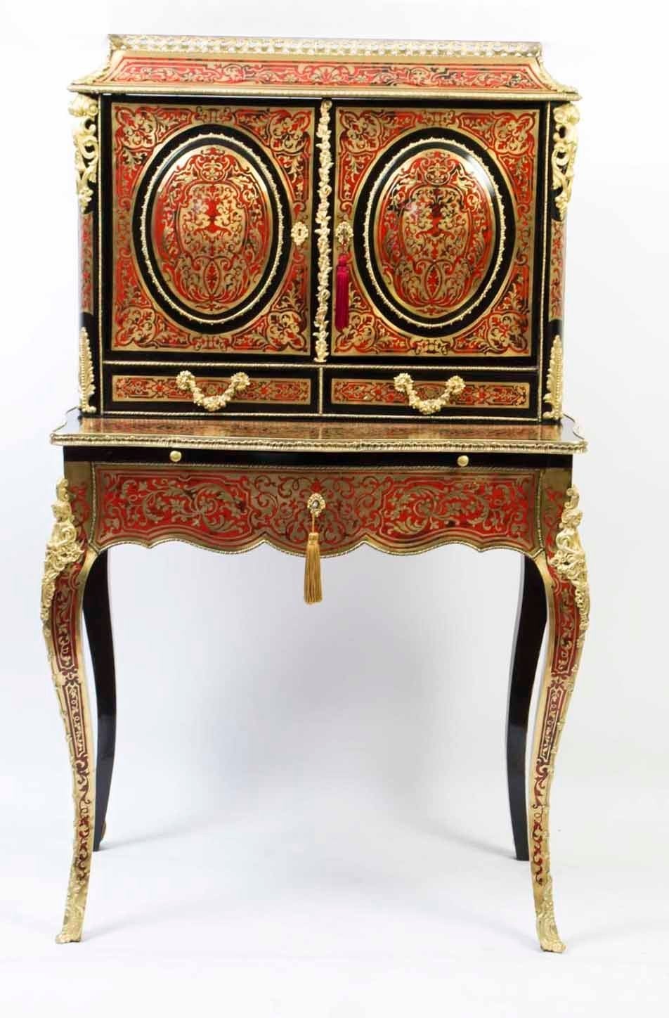 This is a gorgeous antique French Red Tortoiseshell and cut brass inlaid ebonised Boulle, Bureau de Dame or Bonheur du Jour, circa 1870 in date. 

The cavetto top is surmounted with a brass three quarter gallery and has two cupboard doors with