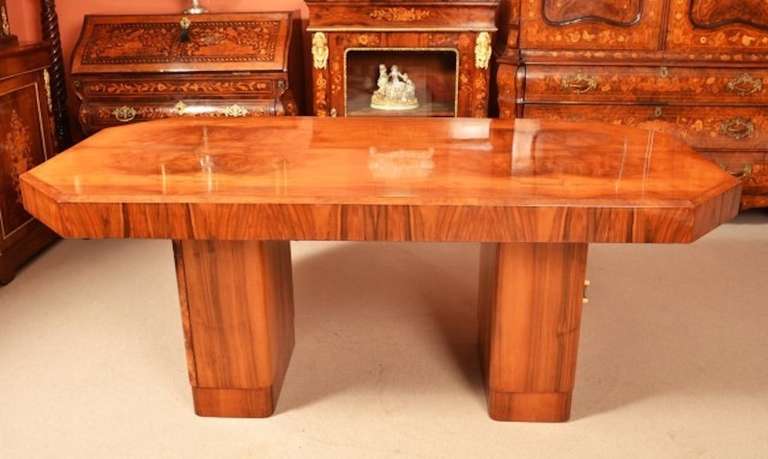 This is a beautiful antique Art Deco burr walnut twin pedestal dining table, circa 1930 in date.

There is unusually a cupboard in each pedestal ,and they provide plenty of space for cutlery and table linen as well as having their original locks,