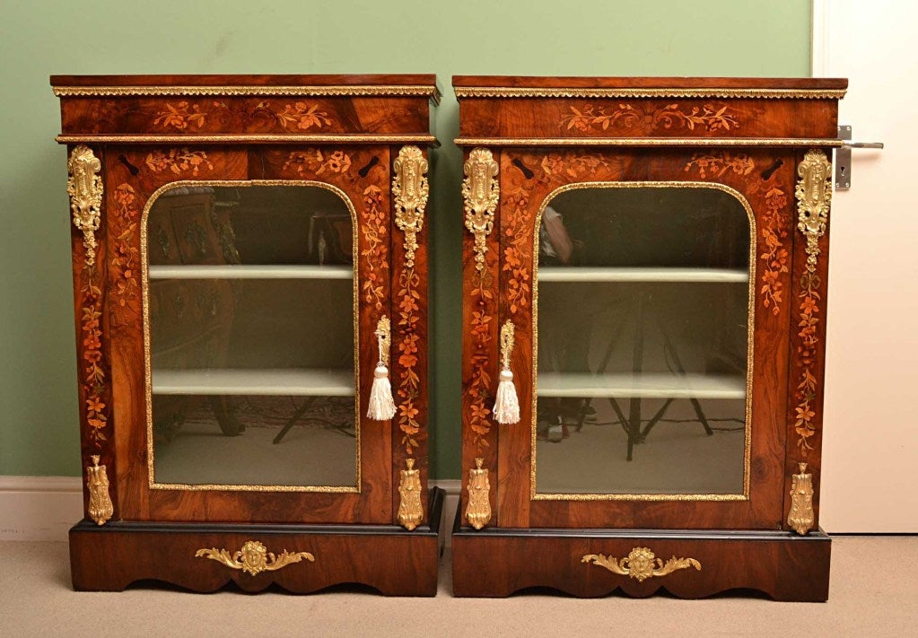 This is a stunning and rare pair of antique Victorian, burr walnut and floral marquetry pier cabinets. They are a genuine pair, which can be seen by the fact that the doors open one to the left and one to the right.

Adding to their truly unique