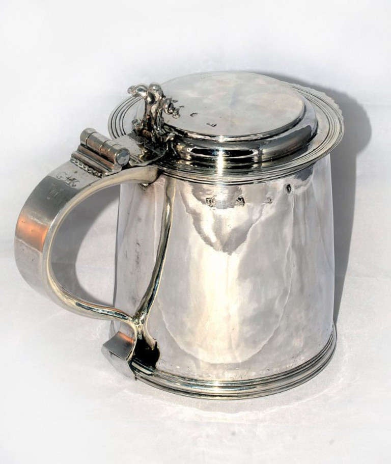 This is a wonderful antique silver Charles II lidded tankard with hall marks for London 1670 and the makers mark T.K. 

The tankard is of cylindrical form with moulded foot, the stepped lid has a scalloped peak, it has an S shaped handle with a