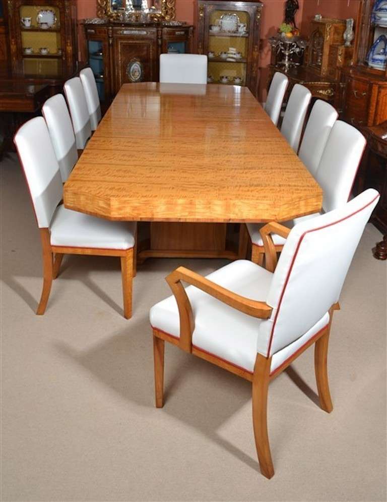 This is a stunning antique Art Deco satinwood and satin walnut dining room suite by the renowned cabinet makers, Waring & Gillow, circa 1920 in date.<br />
This fabulous dining suite comprises: a dining table with two leaves and a set of ten