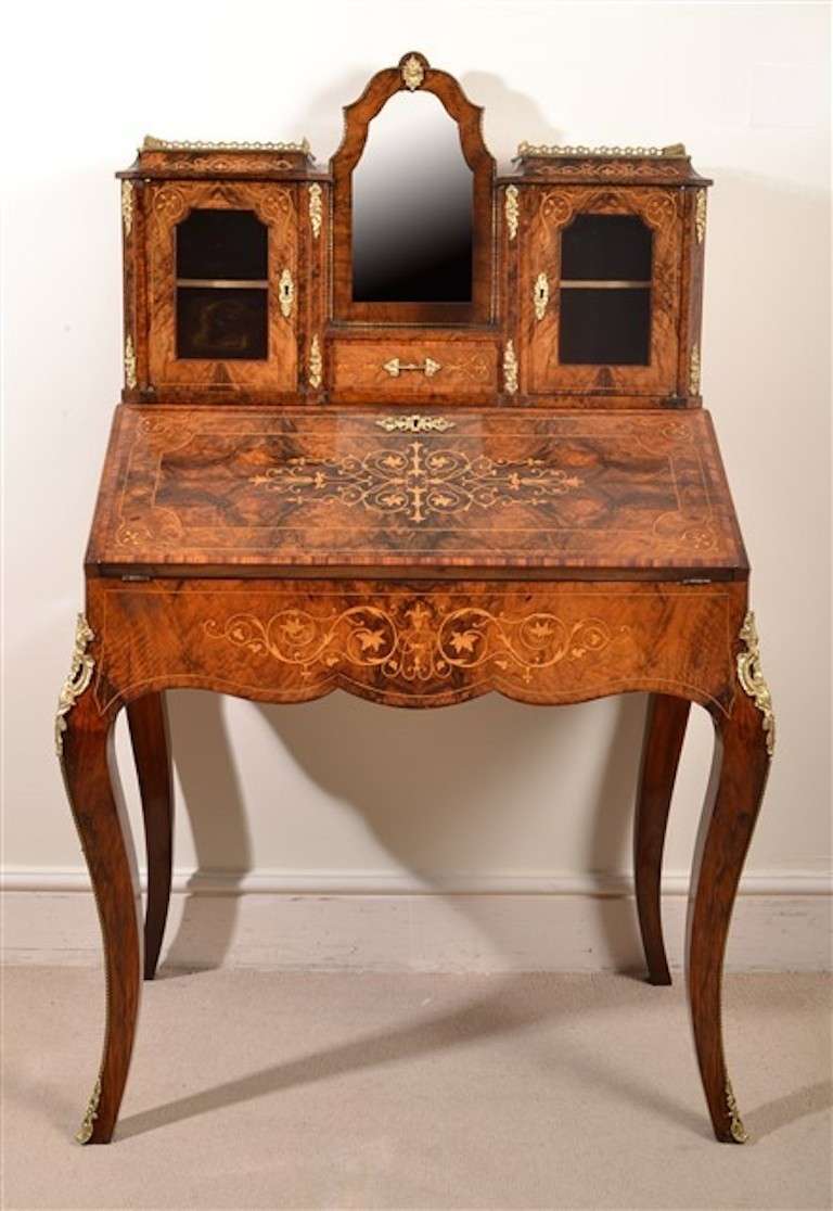 This is a gorgeous Victorian burr walnut and marquetry Bonheur Du Jour, or Ladies writing desk, circa 1860 in date. This is an example of superb quality and design. The gorgeous grain and color of the walnut, the fabulous inlay and the exquisite